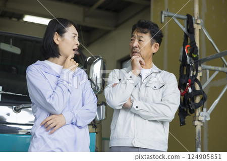 一對經營建築公司的夫婦站在一輛卡車前 124905851