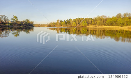 Large pond surrounded by trees and plants. Camping. Spring landscape. Large pond surrounded by trees and plants. Camping. Spring landscape. 124906532