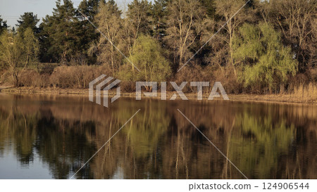 Large pond surrounded by trees and plants. Camping. Spring landscape. 124906544