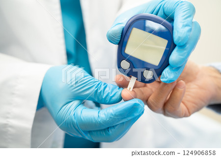 Doctor check diabetes from finger blood sugar level with finger lancet. 124906858
