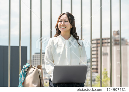 穿著西裝的亞洲女商人在屋頂上使用筆記型電腦 124907581
