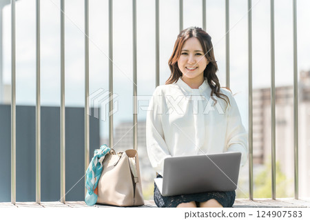 Asian business woman in a suit using a laptop on the rooftop 124907583