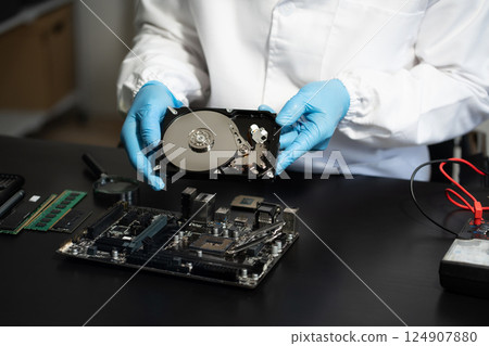 Hands repairing electronic devices. Electronic technician. Hands repairing electronic devices. Electronic technician. 124907880
