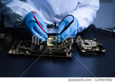 Hands repairing electronic devices. Electronic technician. Hands repairing electronic devices. Electronic technician. 124907900