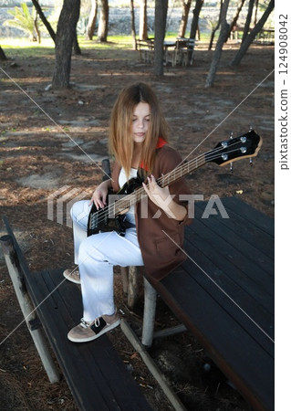 Girl Plays The Bass Instrument In The Countryside In Summer Girl Plays The Bass Instrument In The Countryside In Summer 124908042