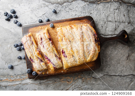Berry puff pastry pie with blueberries and cream cheese close-up on wooden board. Horizontal top view Berry puff pastry pie with blueberries and cream cheese close-up on wooden board. Horizontal top view 124909168