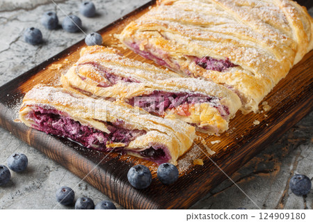 Delicious blueberry pie with fresh berries and patissiere cream close-up on a wooden board. Horizontal Delicious blueberry pie with fresh berries and patissiere cream close-up on a wooden board. Horizontal 124909180