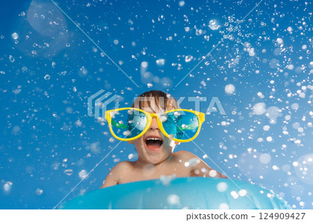 Happy child playing in waterpark. Kid having fun on summer vacation 124909427