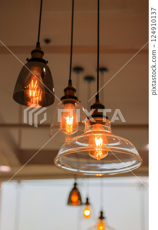 Decorated hanging lamps  and light bulbs decorated in a  living zone. 124910137