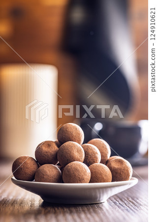 Chocolate truffles with cocoa powder on wooden table. Chocolate truffles with cocoa powder on wooden table. 124910621