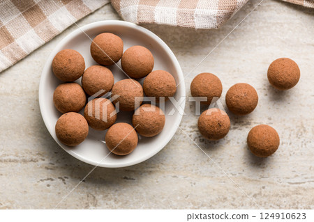 Chocolate truffles with cocoa powder in bowl on kitchen table. Top view. 124910623