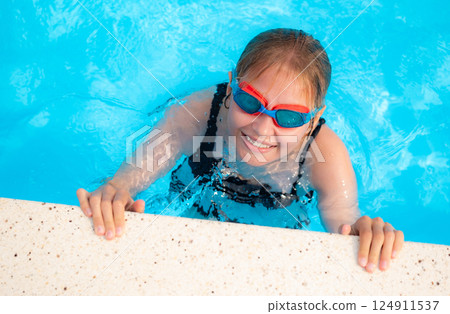 Little Girl Training In An Outdoor Swimming Pool 124911537