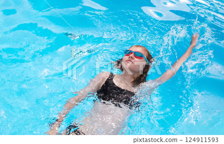 Young Girl Learning Backstroke In Summer Hotel Pool 124911593