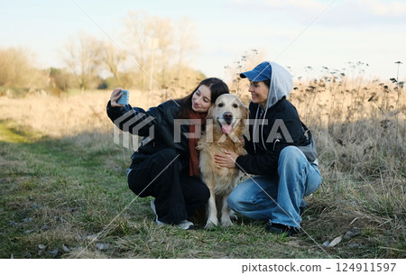 Girls Taking A Selfie With A Golden Retriever Dog Outdoors 124911597