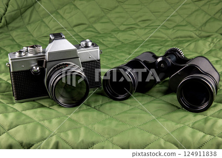 Vintage Film Camera and Binoculars on a Quilted Outdoor Coat 124911838