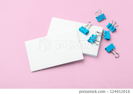 Business card, mockup with blue binder clips on pink background Business card, mockup with blue binder clips on pink background 124912018