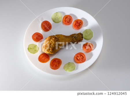 Fried Chicken Leg with Tomato and Cucumber Slices Fried Chicken Leg with Tomato and Cucumber Slices 124912045