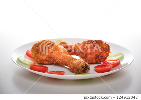 Two Fried Chicken Legs with Tomato and Cucumber 124912048