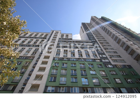 Gazing upwards at a highrise building featuring numerous windows Gazing upwards at a highrise building featuring numerous windows 124912095