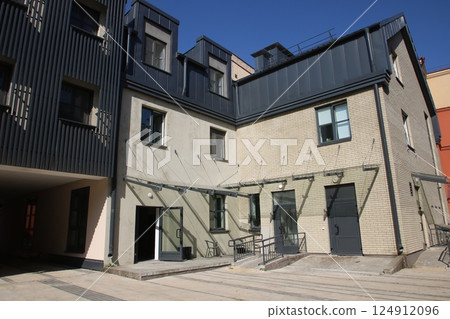 A solid brick building featuring a black roof and stairs leading up to it 124912096