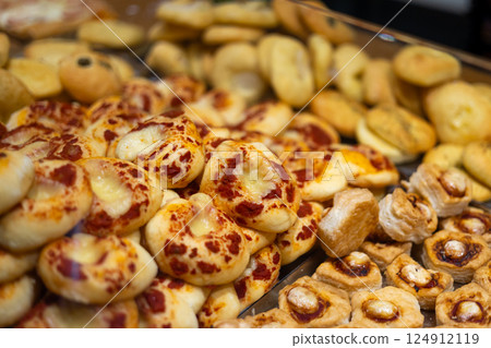 Board with tasty mini pizzas in the shop. Authentic Italian pizza in a restaurant display window. Various pizzeria in glass window display. 124912119