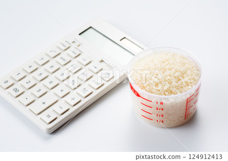 Rice in a measuring cup and a calculator Rice in a measuring cup and a calculator 124912413