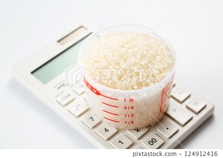 Rice in a measuring cup and a calculator Rice in a measuring cup and a calculator 124912416