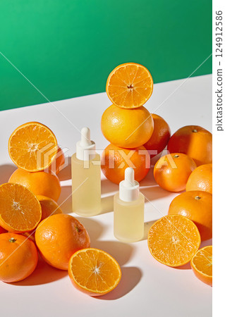 Many oranges are placed randomly around two dropper bottles of serum. Essence extracted from fresh oranges has many benefits in beauty and skincare. The shadows of oranges fall on the table Many oranges are placed randomly around two dropper bottles of serum. Essence extracted from fresh oranges has many benefits in beauty and skincare. The shadows of oranges fall on the table 124912586