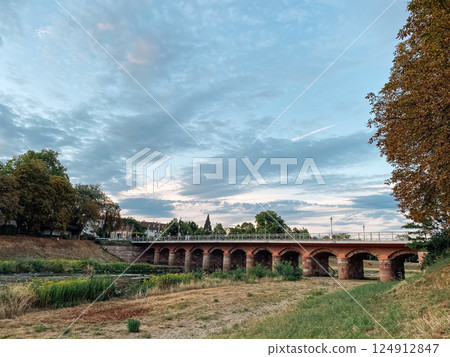 Bridge spans a river with a cloudy sky in the background 124912847