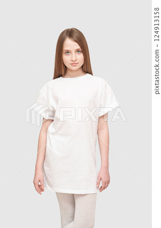 Young caucasian female child in plain white t-shirt posing against neutral Young caucasian female child in plain white t-shirt posing against neutral 124913158