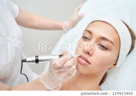 Young caucasian female receiving cosmetic lip treatment at beauty clinic 124913493
