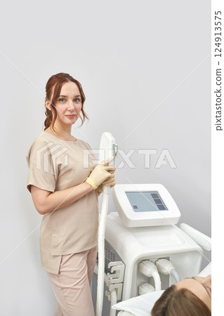 Female caucasian young adult medical professional in spa clinic holding laser 124913575