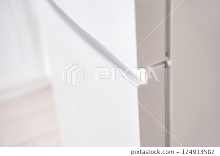 Close up of modern white refrigerator door with seamless handle design in bright 124913582