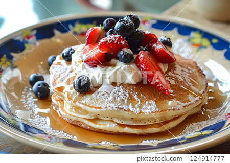 Stack of pancakes with strawberries and blueberries on top. 124914777