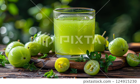 Glass of green juice is on a wooden table with a bunch of green grapes 124915230