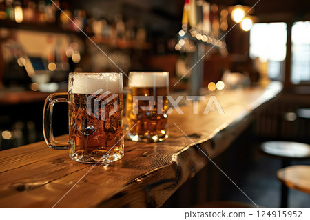 Two glasses of beer on a wooden bar counter. 124915952
