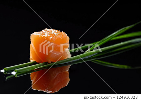 Piece of salmon is sitting on a leafy green stem Piece of salmon is sitting on a leafy green stem 124916328