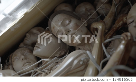 Surreal arrangement of lifelike mannequin faces in a haunting composition 124916565