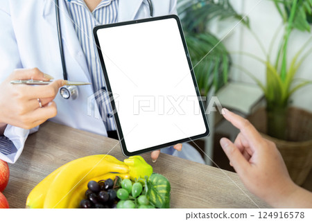 Nutrition and Technology. A healthcare professional presenting a tablet to a patient, integrating technology into nutritional counseling. Nutrition and Technology. A healthcare professional presenting a tablet to a patient, integrating technology into nutritional counseling. 124916578