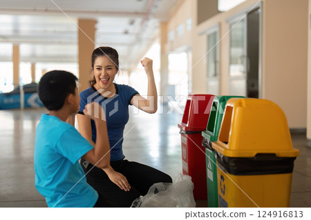 Encouragement and Sustainability Advocacy. Boy celebrates success in learning about recycling with a caretaker. Encouragement and Sustainability Advocacy. Boy celebrates success in learning about recycling with a caretaker. 124916813