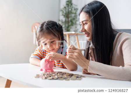 Asian mother supports daughter in financial saving practice indoors Asian mother supports daughter in financial saving practice indoors 124916827