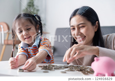 Happy Asian mother and daughter sorting coins together Happy Asian mother and daughter sorting coins together 124916829