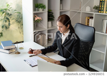 Dedicated Lawyer Reviewing Case Materials in Office Dedicated Lawyer Reviewing Case Materials in Office 124916831