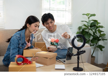 Live Streaming and Online Engagement. A couple preparing for a live session, showcasing their products to an audience. Live Streaming and Online Engagement. A couple preparing for a live session, showcasing their products to an audience. 124917105