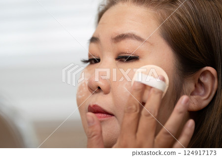 Beauty Application and Makeup Skill. A woman expertly applying makeup with a sponge, highlighting her makeup application technique. 124917173