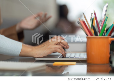 Creative Collaboration and Education. Close up of student hands typing on a laptop while discussing ideas. Creative Collaboration and Education. Close up of student hands typing on a laptop while discussing ideas. 124917263