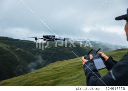 Flying drone in high altitude mountains 124917550