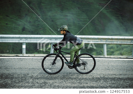 Riding bike on grassland mountain top trail 124917553