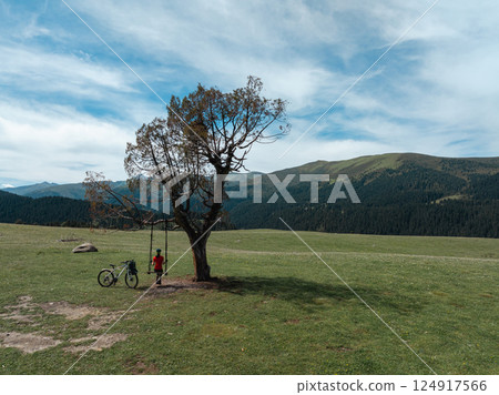 Woman swinging on flowering grassland mountain top 124917566