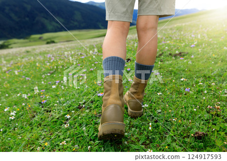 Hiker legs walking on beautiful flowering grassland 124917593